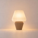 Abajur de mesa Aura aceso, com cúpula branca canelada e base capuccino