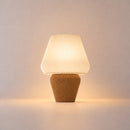 Abajur de mesa Aura aceso, com cúpula branca canelada e base caramelo