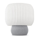 Abajur de mesa com cúpula branca canelada em tambor e base arredondada canelada cinza claro, em fundo branco