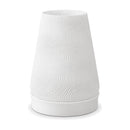 Abajur de mesa com cúpula branca cônica texturizada em ondas e base branca, em fundo branco