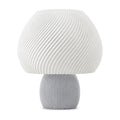 Abajur de mesa com cúpula branca em formato de cogumelo com nervuras em espiral e base canelada cinza claro, em fundo branco