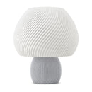 Abajur de mesa com cúpula branca em formato de cogumelo com nervuras em espiral e base canelada cinza claro, em fundo branco
