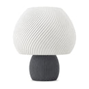 Abajur de mesa com cúpula branca em formato de cogumelo com nervuras em espiral e base canelada grafite, em fundo branco