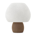 Abajur de mesa com cúpula branca em formato de cogumelo com nervuras em espiral e base canelada marrom, em fundo branco