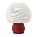 Abajur de mesa com cúpula branca em formato de cogumelo com nervuras em espiral e base canelada vermelho marsala, em fundo branco