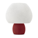 Abajur de mesa com cúpula branca em formato de cogumelo com nervuras em espiral e base canelada vermelho marsala, em fundo branco